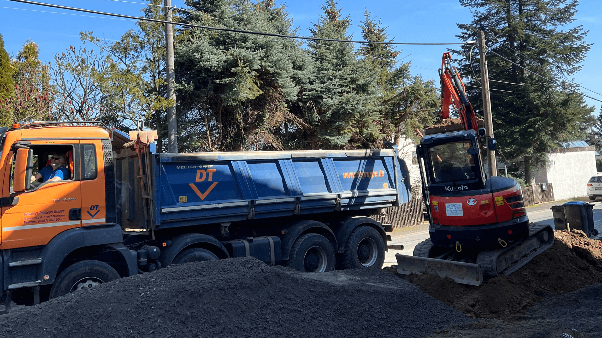 Bagger und LKW beim Erdaushub auf einer Baustelle – typischer Ablauf bei Erdarbeiten im Galabau.
